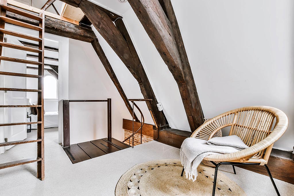 Rustic loft with wooden beams and wicker chair