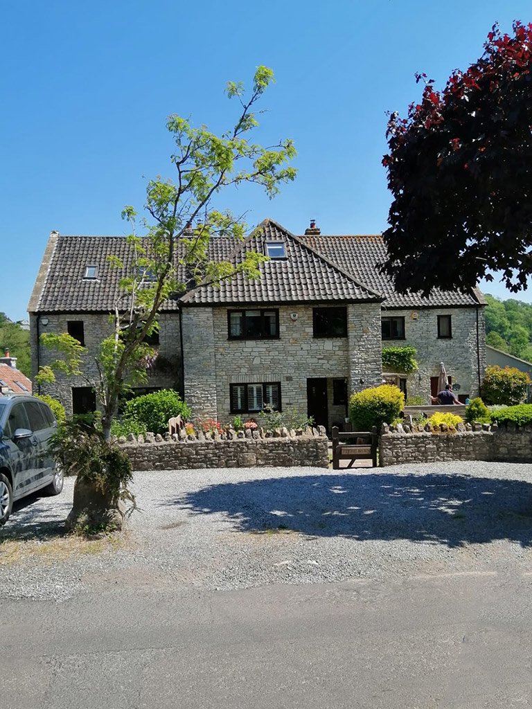 Stone house barn conversion with tile roof and garden.