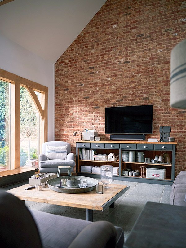 Living room with exposed brick wall and large window.