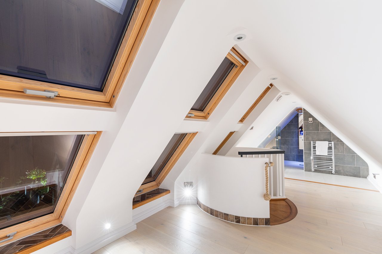 Modern loft attic conversion with skylights and tiled bathroom.