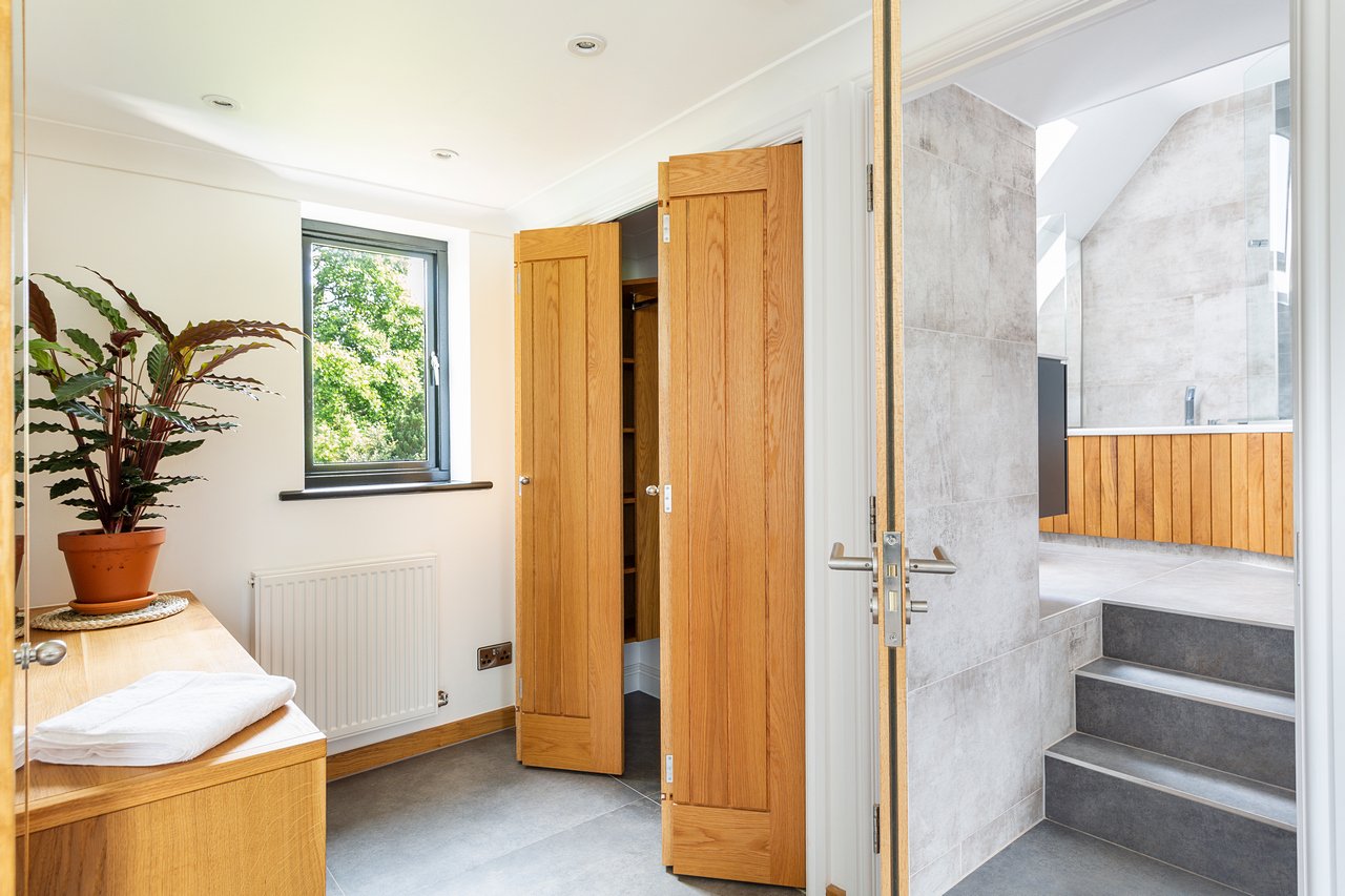 Bright bathroom with wooden doors and stairs, in newly built loft