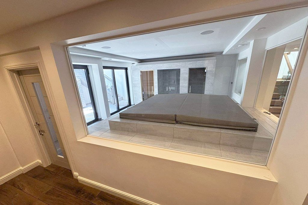 Indoor spa room with covered hot tub in basement new build