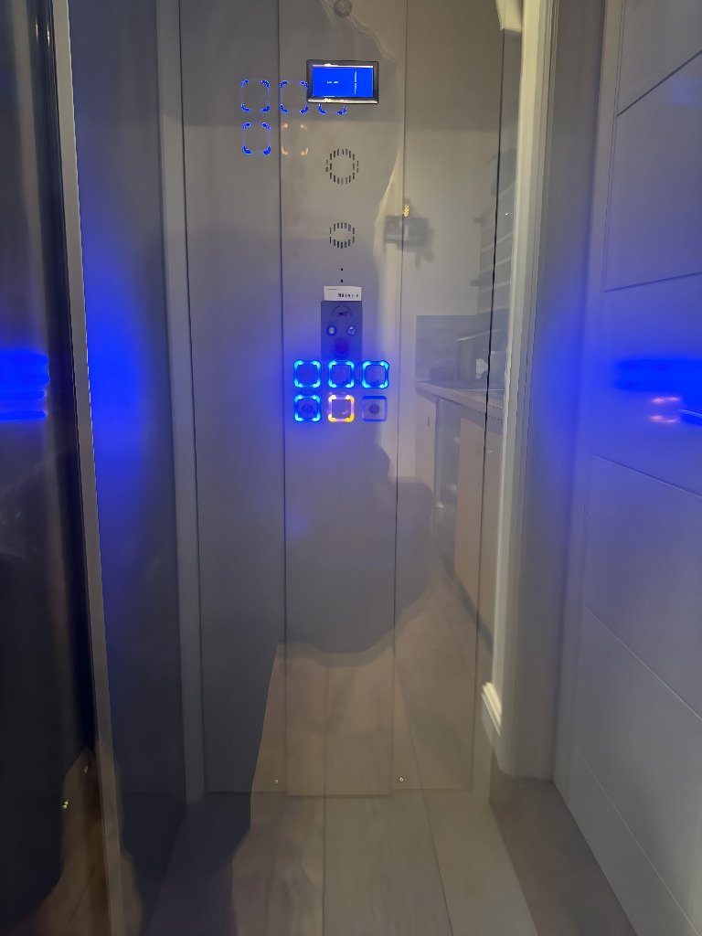 Modern elevator interior with illuminated control panel.